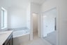 primary bathroom with soaking tub and tile floors 
