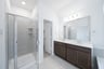 primary bathroom with walk-in shower and tile floors