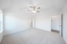 primary bedroom with carpet and ceiling fan