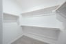 primary bedroom closet with carpet and white shelves