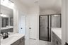 primary bathroom with walk-in shower and tile floors