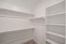 primary bedroom closet with carpet and white shelves