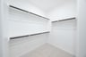 primary bedroom closet with carpet and white shelves