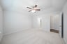 primary bedroom with carpet and ceiling fan