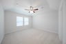 primary bedroom with carpet and ceiling fan