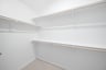 primary bedroom closet with carpet and white shelves