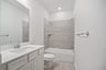 bathroom with tub and white countertops