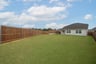 large fenced backyard with covered patio 