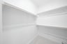 primary bedroom closet with carpet and white shelves