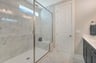 primary shower with a window and a bench