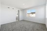 bedroom with gray carpet, white walls, window, and view of attached bathroom