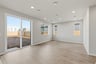 great room with light wood floors, three windows, recessed ceiling lights, and sliding glass door to backyard
