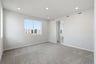 bedroom with gray carpet, window, and view of attached bathroom