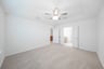 primary bedroom with carpet and ceiling fan