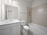 secondary bathroom with soaking tub, quartz countertops & a sink