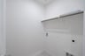 laundry room with tile floors and white shelf