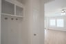 mudroom with wood floors and white shelves with bench