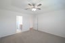 primary bedroom with carpet and ceiling fan