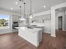 kitchen with quartz countertops, brown flooring & pendant lighting