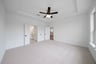 primary bedroom with carpet and ceiling fan