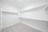 primary bedroom closet with carpet and white shelves