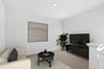 loft with tan carpet, sofa with two black pillows, round black coffee table, modern wall art, and television