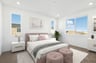 bedroom with tan carpet, pink upholstered bed and ottomans, white dresser & nightstands, and three windows