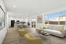 great room with wood floors, large window above white sofa, two yellow accent chairs, modern wall art, and sliding glass door