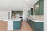 kitchen with green cabinets, white counters, tan tile backsplash, island, and wood floors