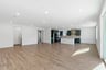 large great room with wood floors, white walls, recessed ceiling lights, and view of kitchen