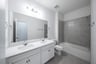 bathroom with two sinks and white cabinets 