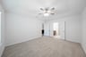 primary bedroom with carpet and ceiling fan