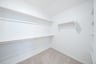 primary bedroom closet with carpet and white shelves