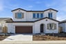 front exterior of two-story white and brown spanish style home