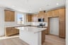 kitchen with light wood cabinets, white counters, island, and window above sink