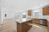 kitchen with light wood floors and cabinets, white quartz counters, island, and window above sink