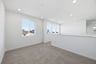 loft with gray carpet, white walls, and multiple windows