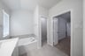 primary bathroom with walk-in shower and white cabinets
