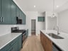 kitchen with pendant lighting, green cabinets & an island sink