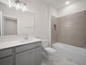 bathroom with quartz countertops & a bathtub