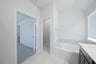 primary bathroom with soaking tub and tile floors 