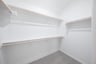 primary bedroom closet with carpet and white shelves
