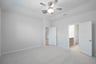 primary bedroom with carpet and ceiling fan