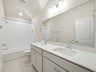 secondary bath with dual sinks and a soaking tub