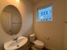 powder room with an oval mirror