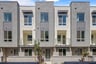 front exterior of three-story gray and tan condo building with courtyards