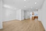 great room with wood floors, white walls, recessed ceiling lights, and view of kitchen