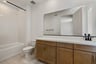 bathroom with wood cabinets, white counters, tan tile floors, and tub with shower overhead