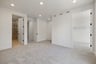 bedroom with gray carpet, white walls, walk-in closet, and view of attached bathroom