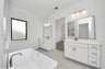 separate sinks with white cabinets and large mirrors